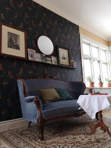 a blue couch in a room with a wall at Disponentparken Café och Bed & Breakfast in Grängesberg