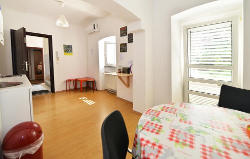 a room with a table and a kitchen with a window at Hostel Temza in Zagreb