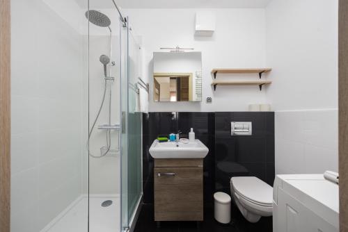 uma casa de banho com um chuveiro, um lavatório e um WC. em Arte Praga Koneser Apartment em Varsóvia