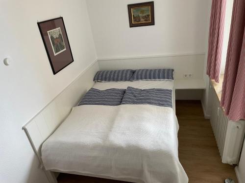 Una cama en un dormitorio con dos almohadas encima. en Haus Uthlande Uthlande Whg 51 Meeresbrise, en Wyk auf Föhr