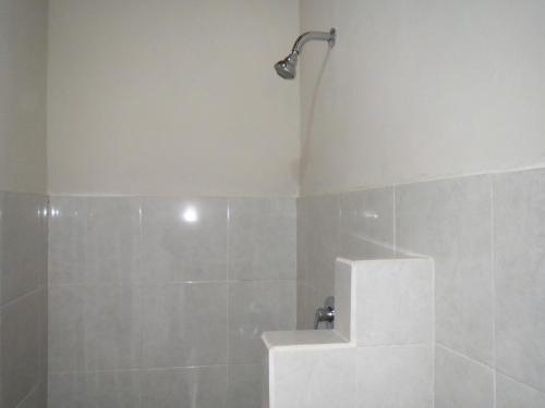 y baño con ducha y lavamanos. en Mesari Homestay & Warung, en Amed