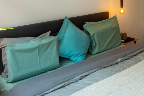 a bed with blue and green pillows on it at Sofia Downtown Boutique Apartment in Sofia