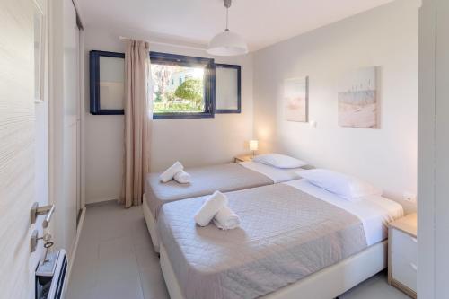 two beds in a white room with white walls at Golden Aura in Danilia