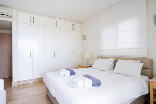 a bedroom with a white bed with towels on it at AAA SEAVIEW PANORAMA in Pervolia