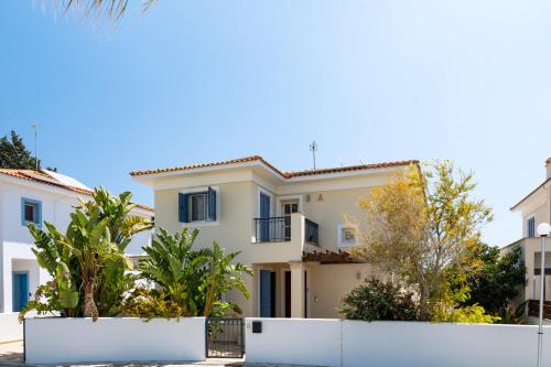 a white house with trees in front of it at AAA SEAVIEW PANORAMA in Pervolia