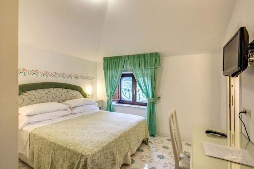 a bedroom with a bed and a window at Hotel La Badia in Sorrento