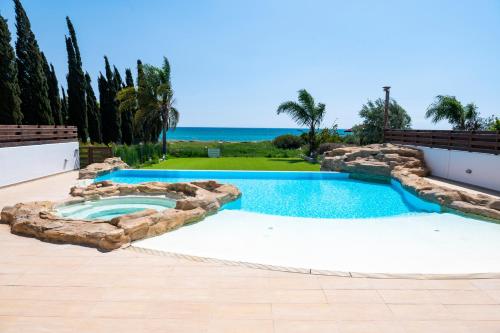 a swimming pool in a backyard with a rock wall at AAA SEAVIEW PANORAMA in Pervolia