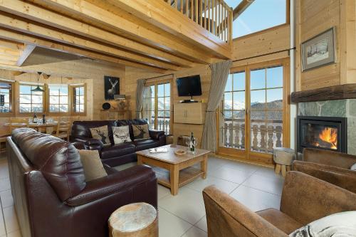 a living room with leather furniture and a fireplace at Chalet Chocolat in La Tzoumaz