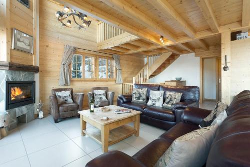 a living room with leather furniture and a fireplace at Chalet Chocolat in La Tzoumaz