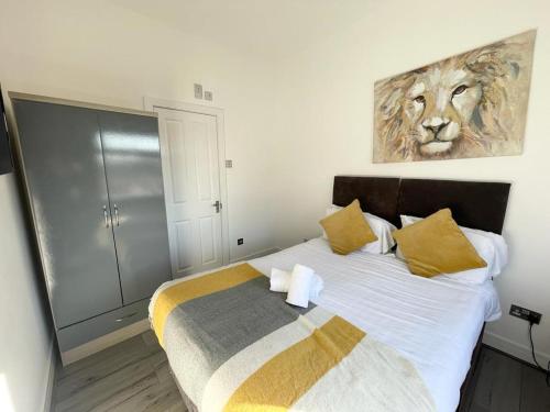 um quarto com uma cama com uma pintura de leão na parede em The Central Suite Sasco Apartments em Blackpool