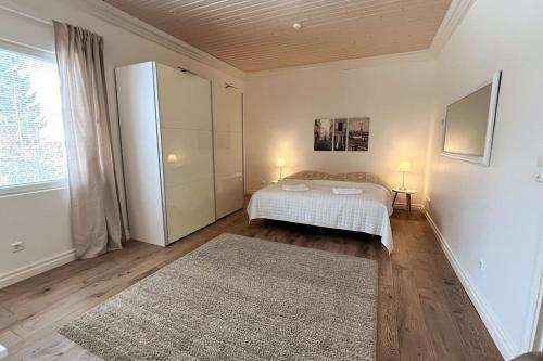 a bedroom with a white bed and a large window at Stunning 5BR 16 Bed Home with Finnish Sauna & Jacuzzi 340 m2 in Tampere