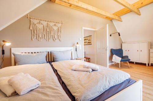 a bedroom with a large bed and a blue chair at Ferienhaus Utkiek in Poseritz