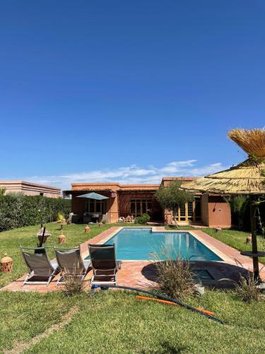 - une piscine avec des chaises et une maison dans l'établissement Villa, piscine sans vis à vis et hammam privé., à Agadir Toudras