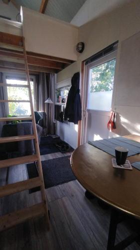 a room with a ladder and a table in a room at Tuinhuisje in het groen in Almere