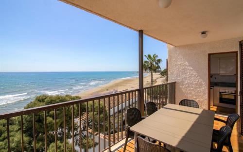 a balcony with a table and a view of the beach at Apartamento con vistas frontales - Primera línea Playa Cargador - ALBERT VILLAS in Alcossebre