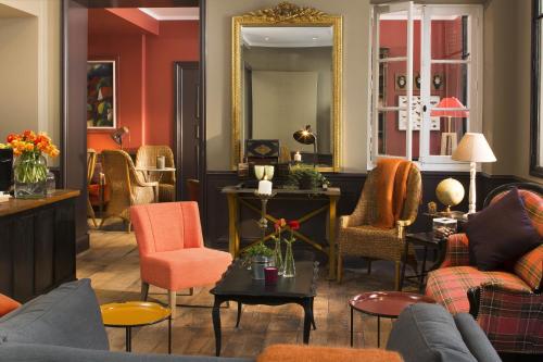 a living room filled with furniture and a mirror at Hotel Le Petit Chomel in Paris