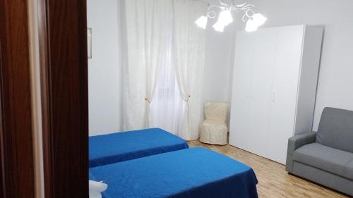 聖薩維諾山的住宿－dalla CARLA in Toscana，一间卧室配有两张蓝色的床和椅子