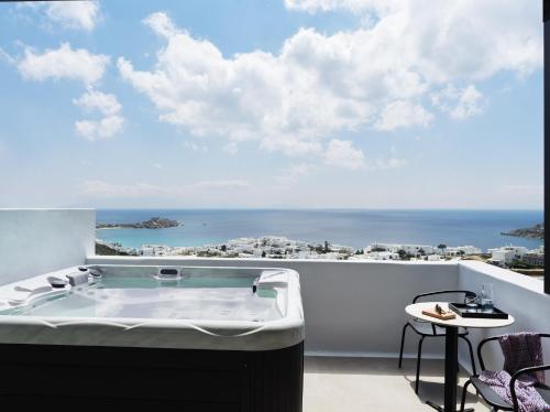 a bath tub on a balcony with a view of the ocean at Ezio Bo Luxury Living in Mýkonos City