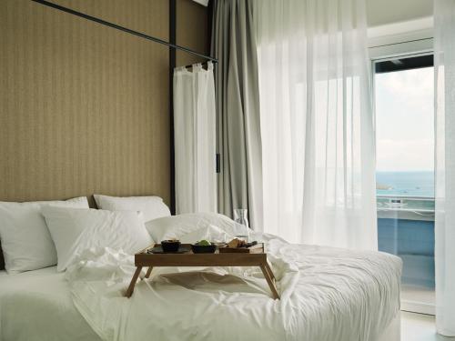 a bedroom with a white bed with a table on it at Ezio Bo Luxury Living in Mýkonos City