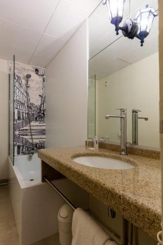 une salle de bain avec un lavabo et un miroir dans l'établissement Hôtel de France, à Toulouse