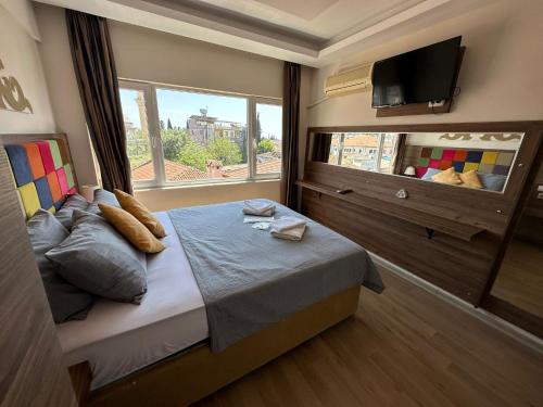 a bedroom with a bed with a window and a television at Hotel Twenty in Antalya