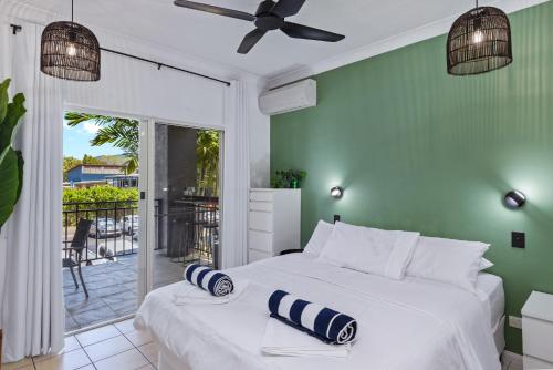um quarto com uma cama branca e uma parede verde em Zion Escapes Cairns City Waters Edge Family Apartment em Cairns