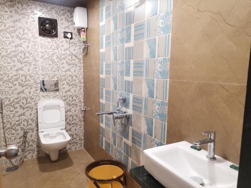 a bathroom with a toilet and a sink at Raaj Resort in Panvel