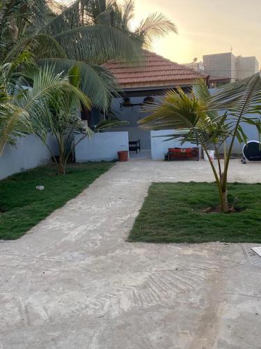 a house with two palm trees in front of it at silla in Mbour