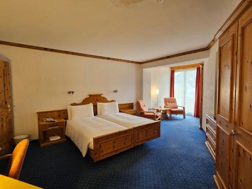 a hotel room with a large bed and a desk at Hotel Schweizerhof Pontresina in Pontresina