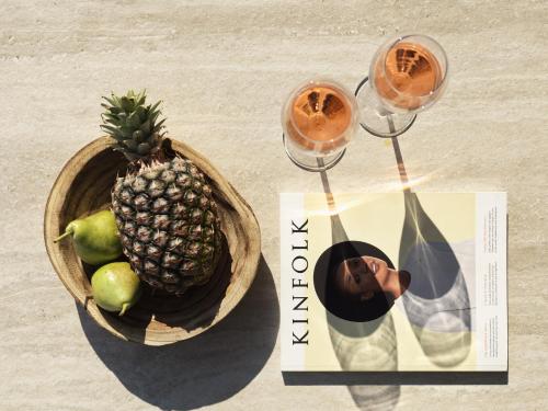 a book and two glasses of wine and a bowl of fruit at Ezio Bo Luxury Living in Mýkonos City