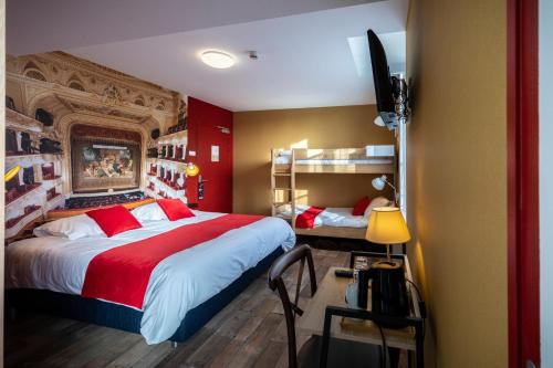 een slaapkamer met een groot bed en een bureau met een televisie bij L'Auberge des Artistes in Nieul-sur-lʼAutise