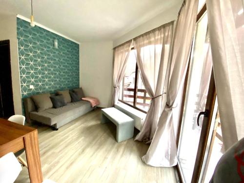 a living room with a couch and a window at Vila Mama Jana in Buşteni
