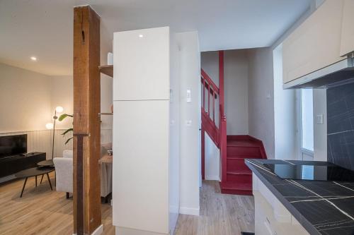 een keuken met een witte koelkast en een woonkamer bij The Adour - Apartment 42 m in Vic-en-Bigorre