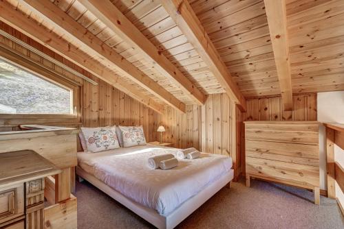 a bedroom with a bed in a wooden cabin at Chalet Claire de Soleil in La Tzoumaz