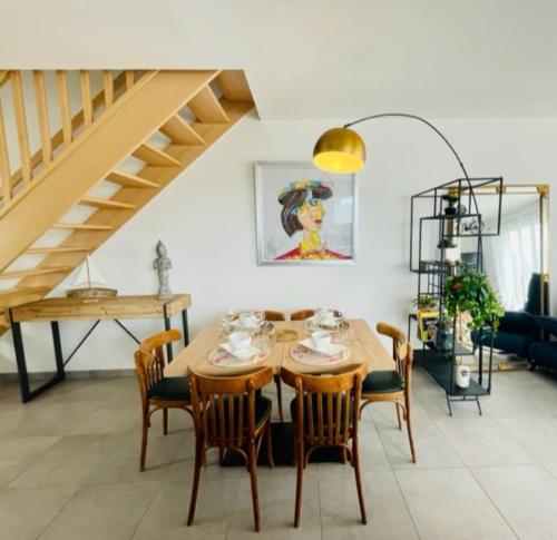 uma sala de jantar com uma mesa de madeira e cadeiras em A charming house in Puilboreau em Puilboreau