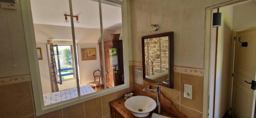 La salle de bains est pourvue d'un lavabo et de deux miroirs. dans l'établissement Auberge De Bel Air, à Brélès