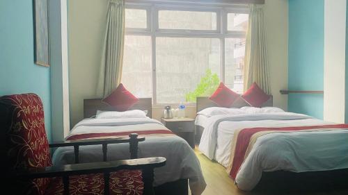 Hotel Discovery Inn في كاتماندو: غرفة نوم بسريرين ونافذة
