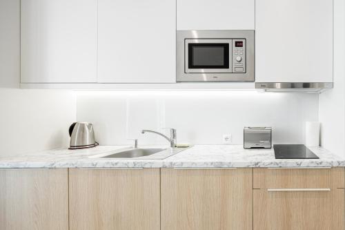 a kitchen with a sink and a microwave at VacationClub - Boulevard Residence Apartament 1 in Ustronie Morskie