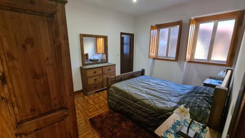 a bedroom with a bed and a dresser and a mirror at Casa das Tílias in Alvaro