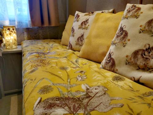 uma cama com um edredão amarelo com animais em Glan Hirfaen Where the mountains meet the sea em Porthmadog