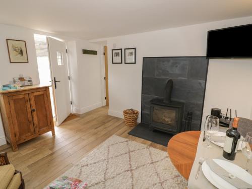 a living room with a fireplace and a table at The Little Cottage in Banbury