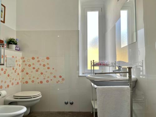 un bagno con un water, un lavandino e una finestra di Home Dolce Casa Apartment a La Spezia