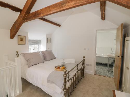 ein Schlafzimmer mit einem Bett und ein Badezimmer mit einer Badewanne in der Unterkunft The Little Cottage in Banbury