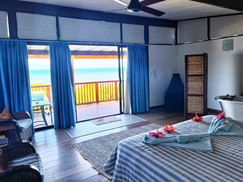 una camera da letto con un letto con vista sull'oceano di Kob Inn Beach Resort a Qora Mouth