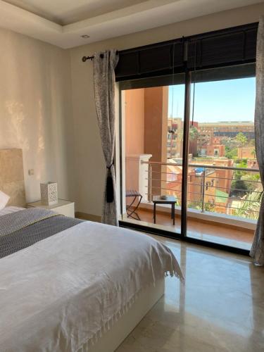 a bedroom with a bed and a large window at Résidence Las Palmeras in Marrakesh