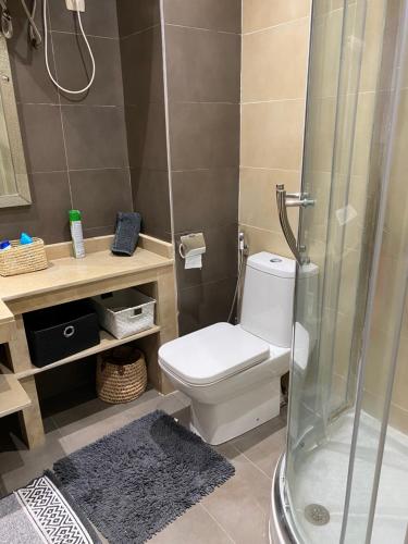 a bathroom with a white toilet and a shower at Résidence Las Palmeras in Marrakesh