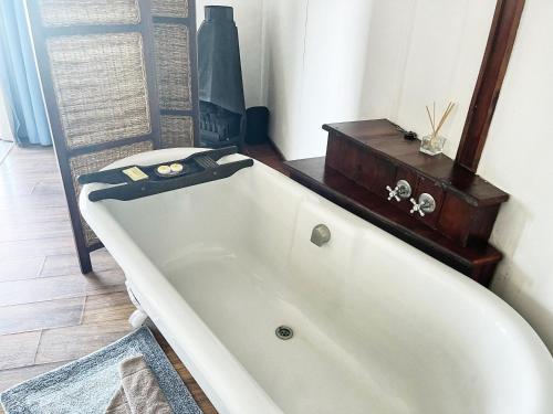 una vasca da bagno bianca seduta in bagno di Kob Inn Beach Resort a Qora Mouth