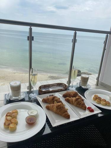 two plates of pastries on a table with a view of the ocean at Design Hotel Skopeli in Odesa
