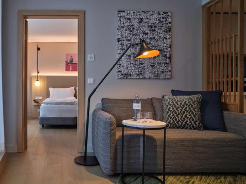 a living room with a couch and a lamp and a bed at Adina Apartment Hotel Vienna Belvedere in Vienna