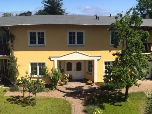 ein gelbes Haus mit weißer Tür in der Unterkunft Ferienwohnung Mühlenblick in Benz